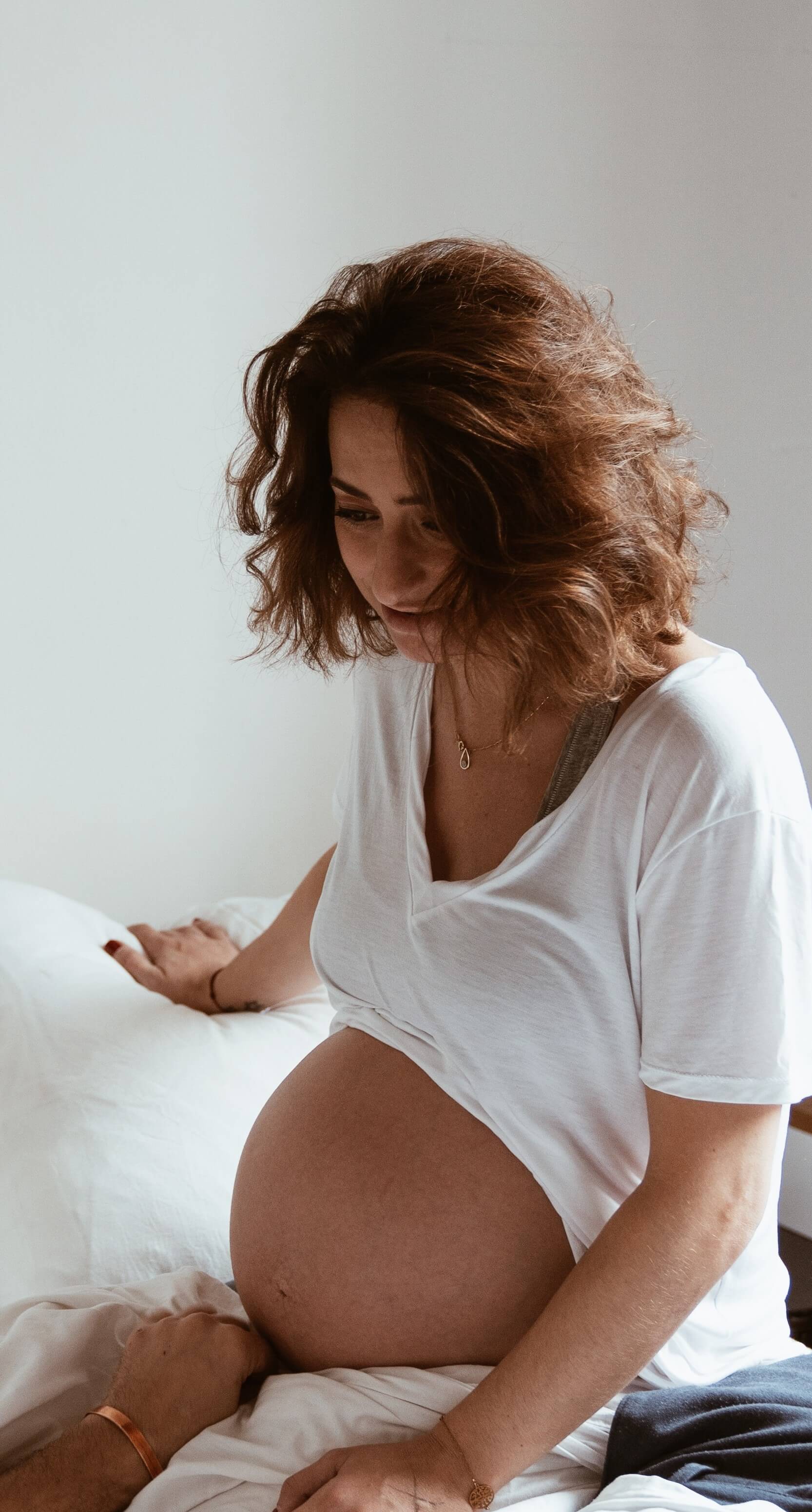 femme enceinte sur ses genoux ventre nu